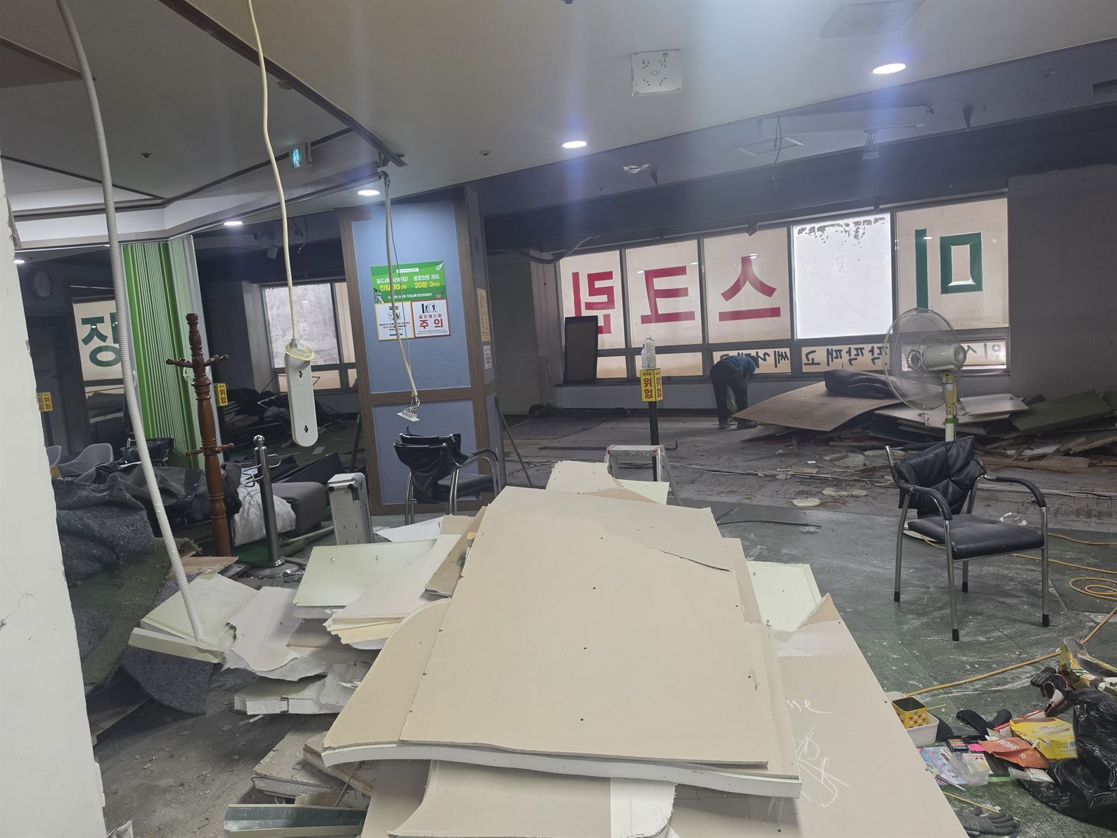실내 바닥에 쌓인 판재와 천장에서 늘어진 선